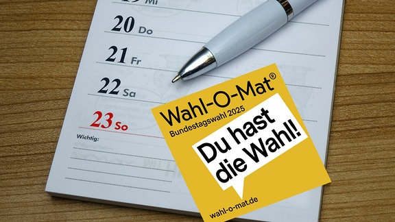 Auf einem Kalender befindet sich ein Kugelschreiber mit einem Flyer des Wahl O Mat.