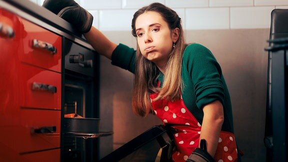 Müde Hausfrau backt bis spät in die Nacht einen Kuchen.