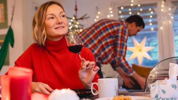 Nachdenkliche blonde Frau trinkt Rotwein