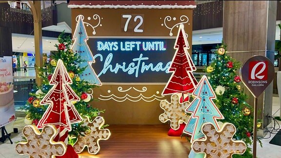 In einem Einkaufszentrum in Manila ist weihnachtliche Beleuchtung zu sehen sowie eine Leuchttafel, auf der die Tage bis Weihnachten heruntergezählt werden.