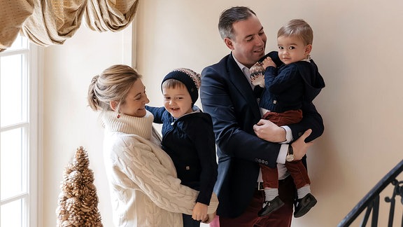 Vierköpfige Familie posiert auf einer Treppe für ein Foto.