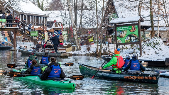 Paddler und Spreewaldkähne erreichen den Hafen des Spreewalddorfes Lehde.