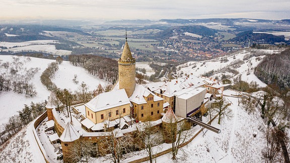 Eine Außenansicht der Leuchtenburg bei Schnee.