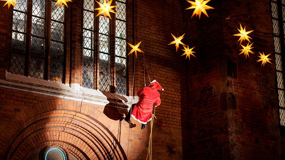 Der Nikolaus steigt in Lübeck aus der Jakobi-Kirche ab.