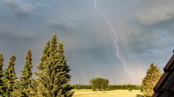 Landschaftsaufnahme mit einem Blitz der in der Ferne einschlägt