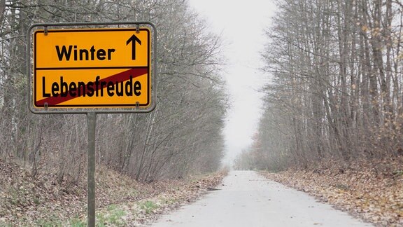 Auf einem Straßenschild steht "Winter" und darunter durchgestrichen "Lebensfreude".