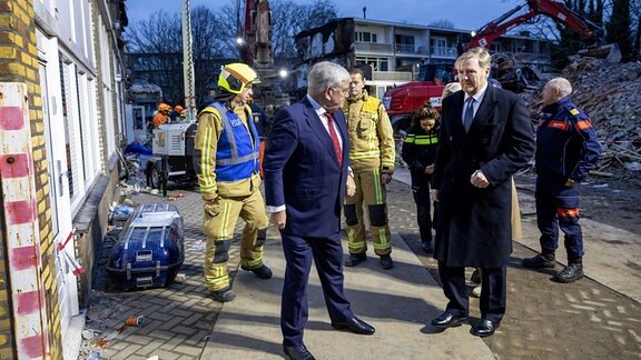 König Willem-Alexander steht neben Einsatzkräften