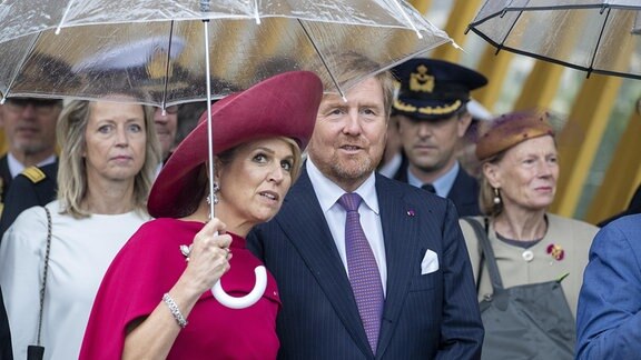 Willem-Alexander & Maxima unter einem Regenschirm.