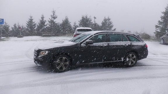 Eingeschneites Auto in einer Winterlandschaft