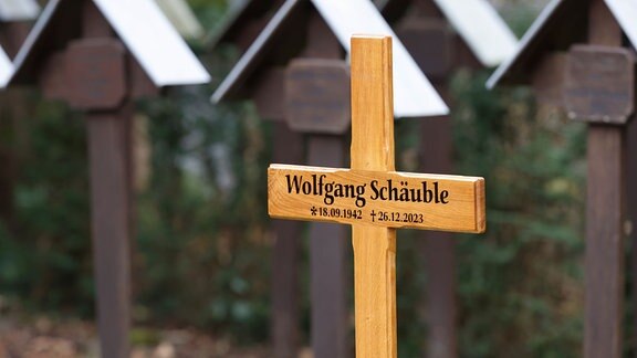 Ein Kreuz kennzeichnet am Rande der Trauerfeier für Wolfgang Schäuble die Grabstätte auf dem Friedhof. 
