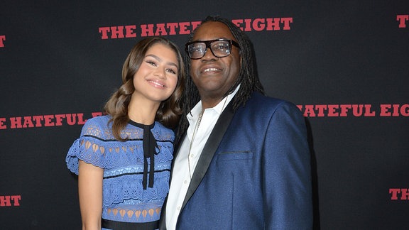 Paarportrait vor einer Wand mit der Aufschrift "The Hateful Eight"